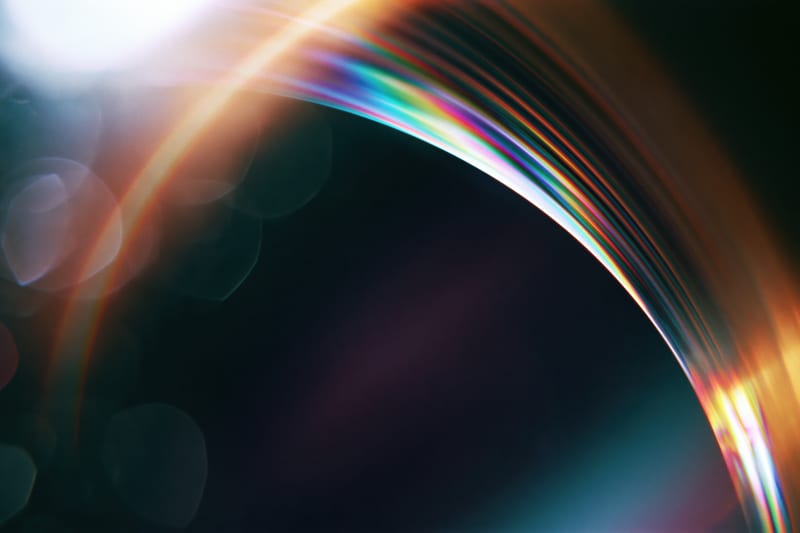 A rainbow lens flare arcing across a dark background